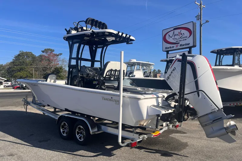 Slide: The Image of 2024 Tidewater 2500 Carolina Bay boat with powerful outboard engines displayed outdoors. - 2
