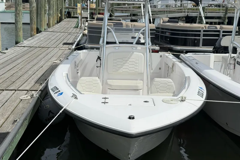 Slide: The Image of 2024 Aquasport 2200 Center Console boat docked at marina, featuring sleek design and spacious seating. - 3