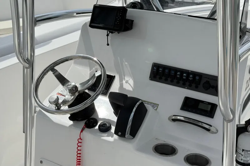 Slide: The Image of 2024 Aquasport 2200 Center Console boat dashboard with steering wheel and controls. - 5
