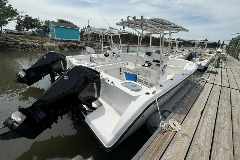 Slide: The Image of 2024 Aquasport 2200 Center Console boat docked with dual Mercury engines. - 8