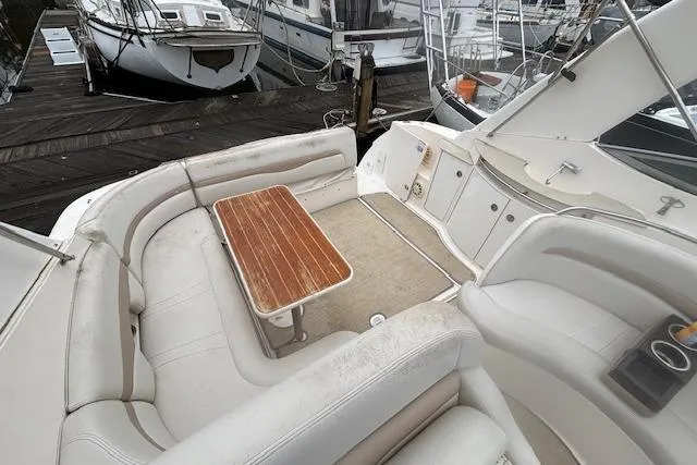 Slide: The Image of 2002 Chaparral Signature 350 boat interior with seating and wooden table at marina. - 11