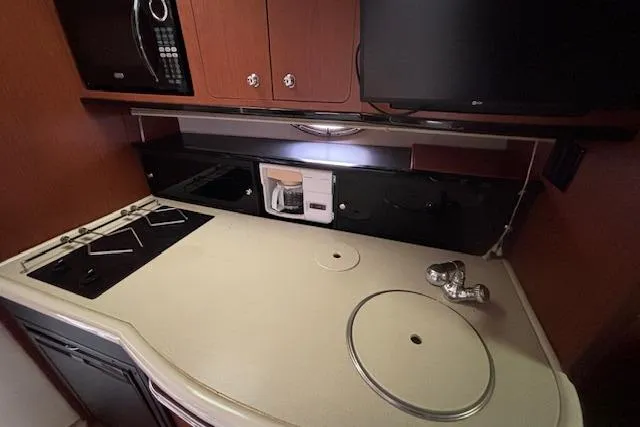Slide: The Image of 2002 Chaparral Signature 350 yacht kitchen with stove, microwave, and sink. - 18