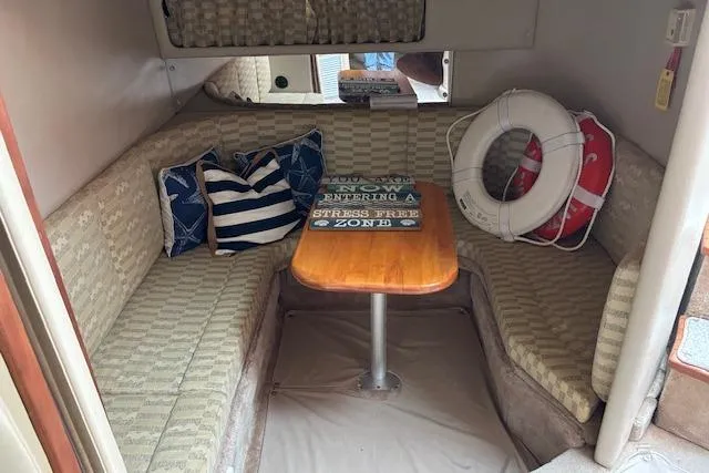 Slide: The Image of 2002 Chaparral Signature 350 cabin interior with seating, table, and nautical decor. - 21