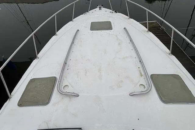 Slide: The Image of 2002 Chaparral Signature 350 boat deck with railing and hatches, docked by calm water. - 8