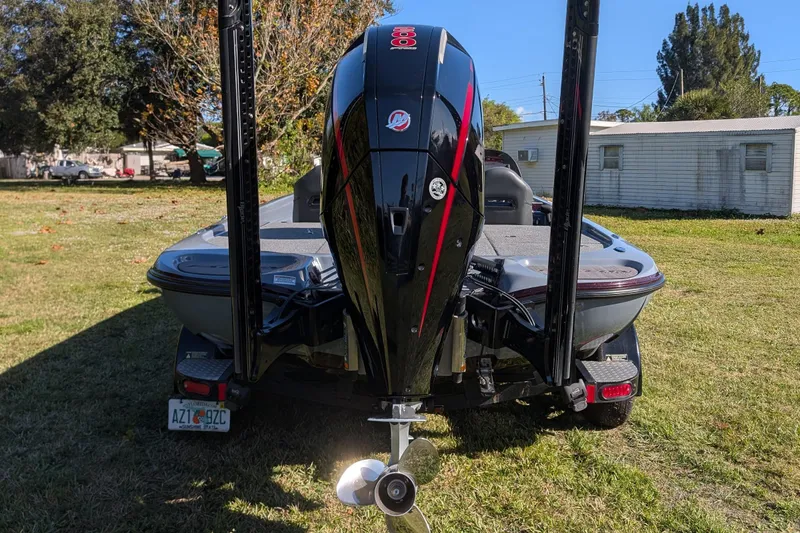 Slide: The Image of 2023 Falcon F195 boat with powerful outboard motor, parked on grass. - 13