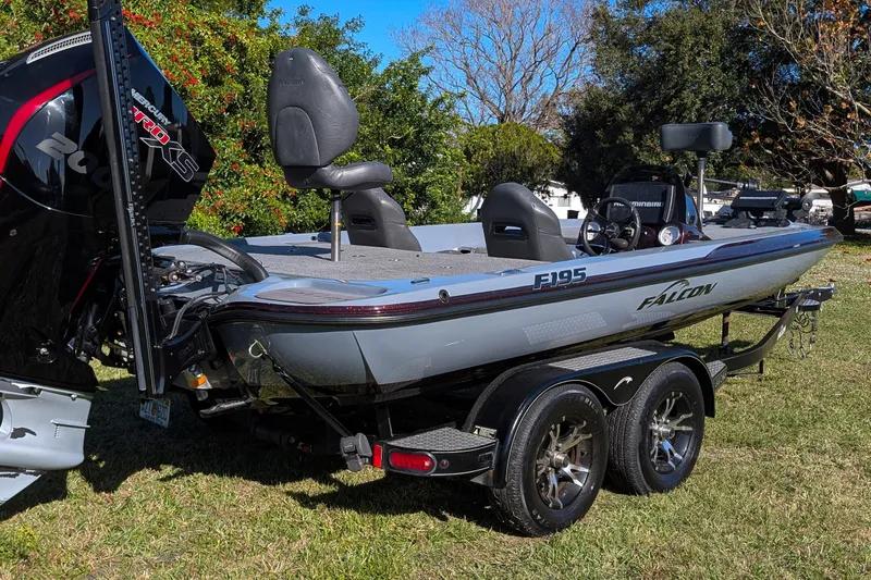Slide: The Image of 2023 Falcon F195 boat on trailer, featuring Mercury Pro XS engine, parked on grass. - 15