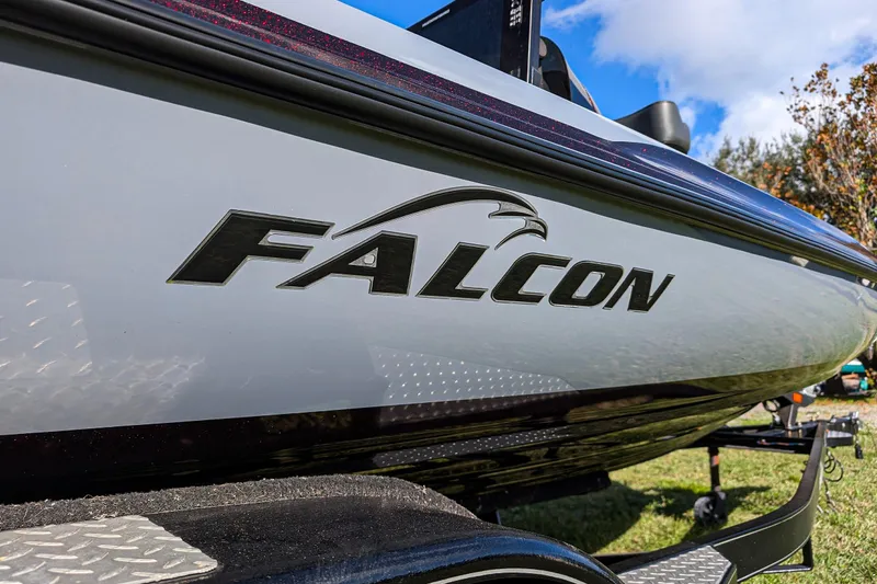 Slide: The Image of 2023 Falcon F195 boat deck with Humminbird electronics, featuring a spacious carpeted layout. - 7
