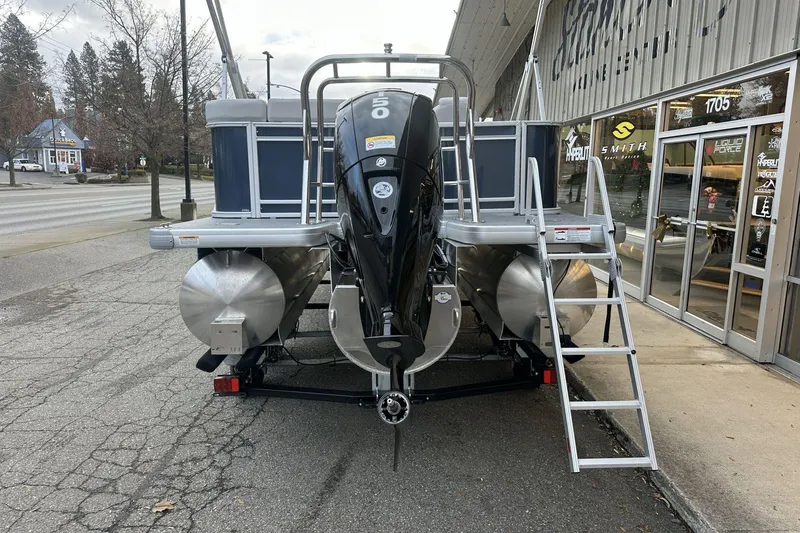 Slide: The Image of 2026 Godfrey SWEETWATER 2286 CSE pontoon boat with outboard motor, parked outside a store. - 10