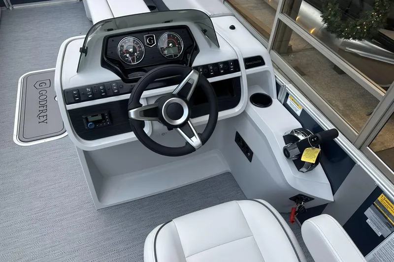 Slide: The Image of 2026 Godfrey SWEETWATER 2286 CSE boat dashboard with steering wheel and controls. - 3