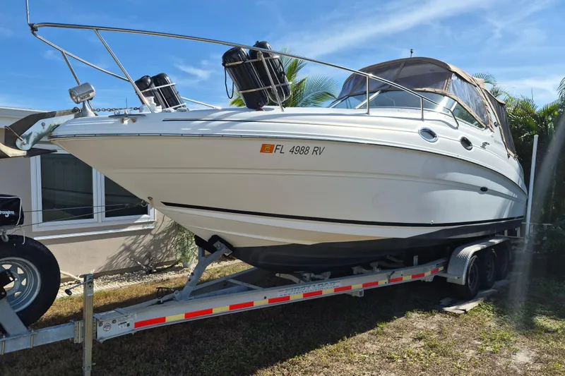 The Image of 2001 Sea Ray Sundancer 280 boat on trailer, parked outdoors under clear sky. - 0
