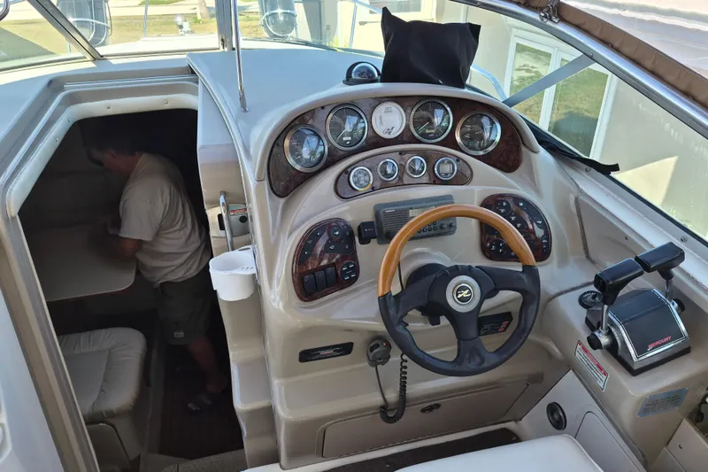 Slide: The Image of 2001 Sea Ray Sundancer 280 helm with gauges, steering wheel, and cabin entrance. - 14
