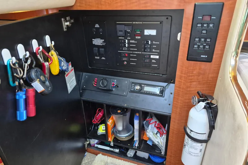Slide: The Image of Control panel and storage area inside a 2001 Sea Ray Sundancer 280 boat. - 19