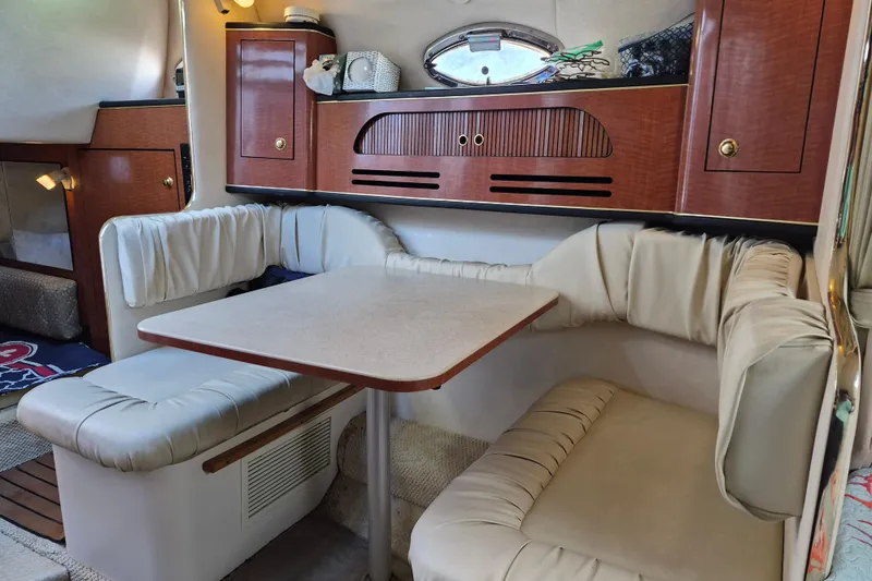 Slide: The Image of 2001 Sea Ray Sundancer 280 interior with cozy dining area and elegant wood cabinetry. - 21