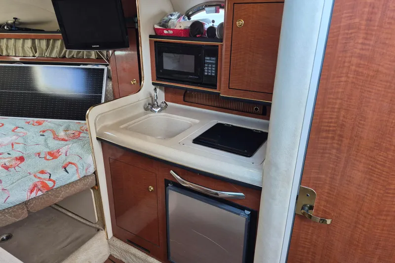 Slide: The Image of 2001 Sea Ray Sundancer 280 interior with kitchenette, microwave, and bed. - 22