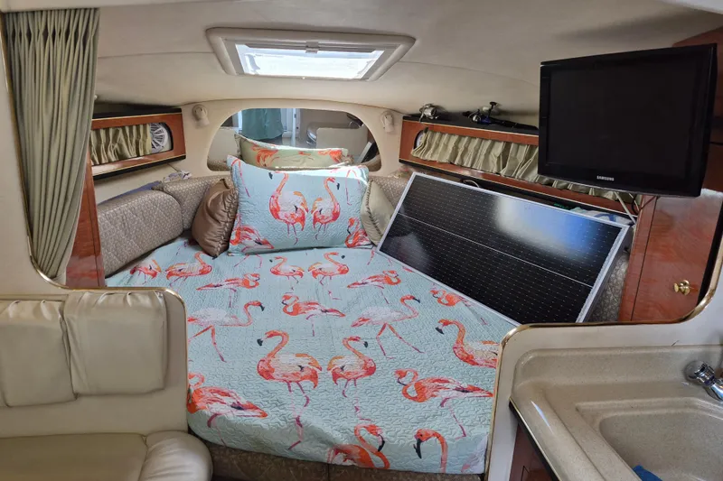Slide: The Image of 2001 Sea Ray Sundancer 280 cabin with flamingo bedding and solar panel. - 23