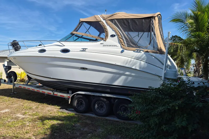 Slide: The Image of 2001 Sea Ray Sundancer 280 boat on trailer, parked outdoors with palm trees. - 5