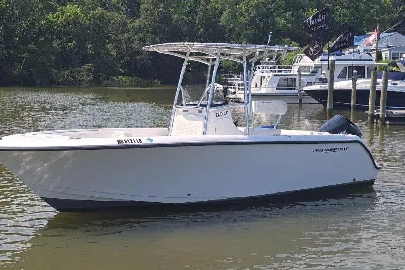 Slide: The Image of 2024 Aquasport 2200 Center Console boat on calm water near docks. - 4