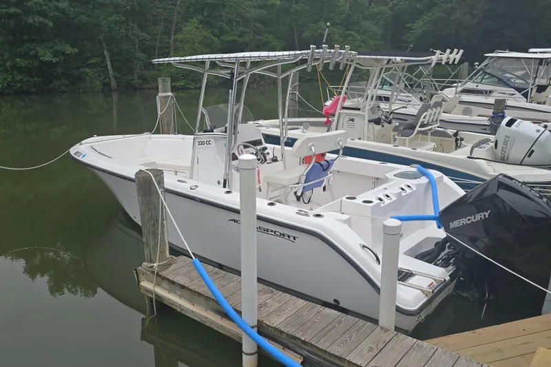 Slide: The Image of 2024 Aquasport 2200 Center Console boat docked with Mercury engine. - 6
