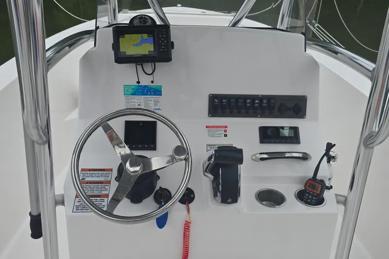 Slide: The Image of 2024 Aquasport 2200 Center Console dashboard with steering wheel and navigation equipment. - 8