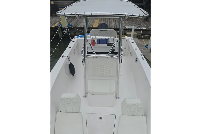 Slide: The Image of 2024 Aquasport 2200 Center Console boat with T-top and seating, docked at marina. - 9