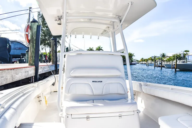 Slide: The Image of 2014 Regulator 28 boat interior with white seating, dockside view, and calm waters. - 11