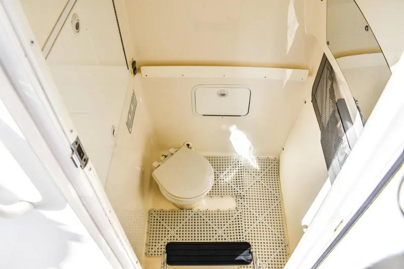 Slide: The Image of 2014 Regulator 28 boat interior with compact marine toilet and storage compartment. - 8