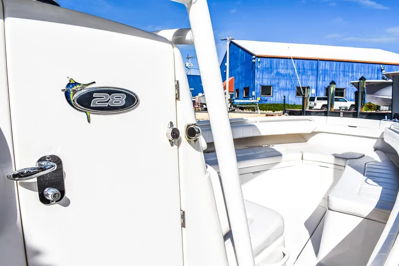 Slide: The Image of 2014 Regulator 28 boat interior with seating, docked near blue building. - 9
