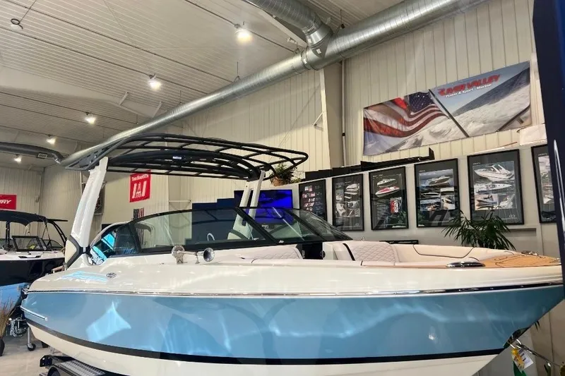 The Image of 2025 Chris-Craft Sportster 25 boat displayed in a showroom with modern interior design. - 1