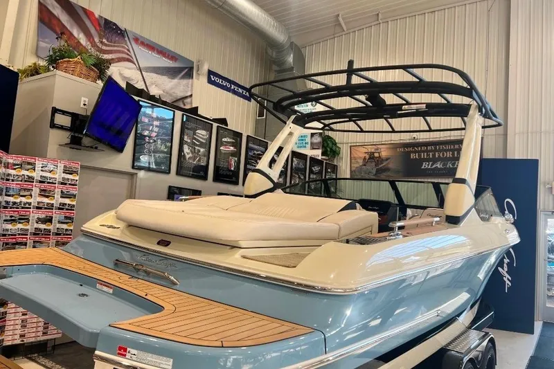 Slide: The Image of 2025 Chris-Craft Sportster 25 boat displayed indoors, showcasing sleek design and luxury features. - 2