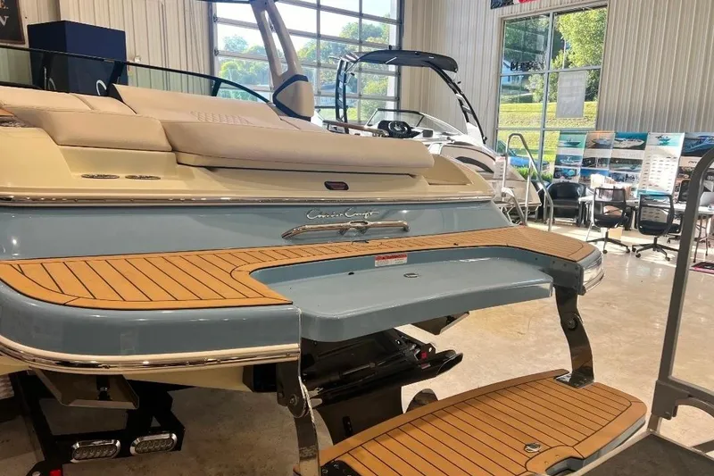 Slide: The Image of 2025 Chris-Craft Sportster 25 boat with elegant teak swim platform in showroom. - 3