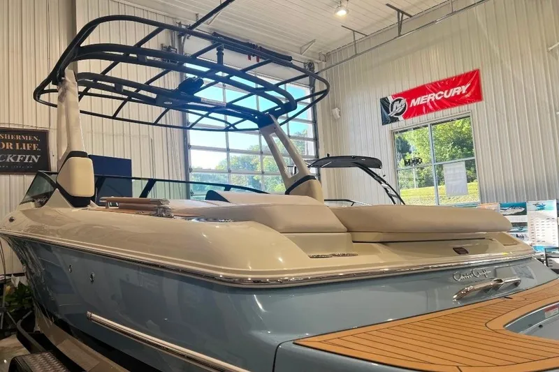 Slide: The Image of 2025 Chris-Craft Sportster 25 boat in showroom, featuring sleek design and modern amenities. - 4