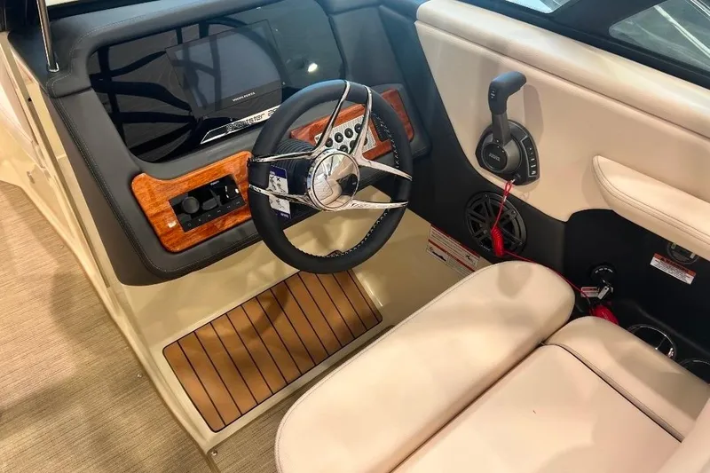 Slide: The Image of 2025 Chris-Craft Sportster 25 interior with modern steering wheel and wood accents. - 8