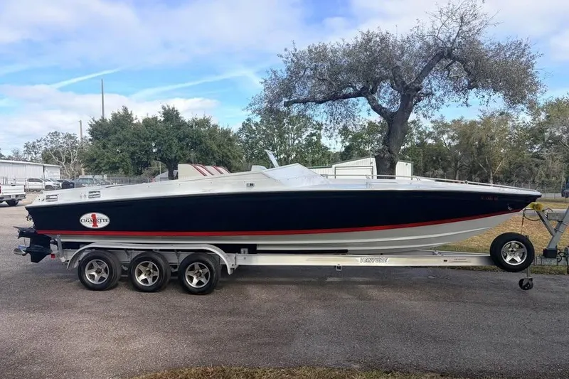 Slide: The Image of 1983 Cigarette 24' Classic speedboat on trailer, parked outdoors. - 1