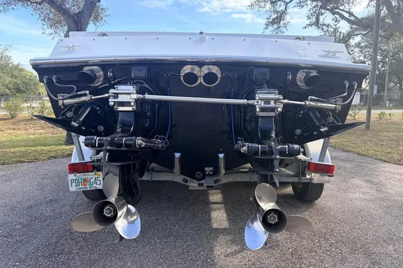 Slide: The Image of Rear view of a 1983 Cigarette 24' Classic boat on a trailer, showcasing dual propellers. - 17