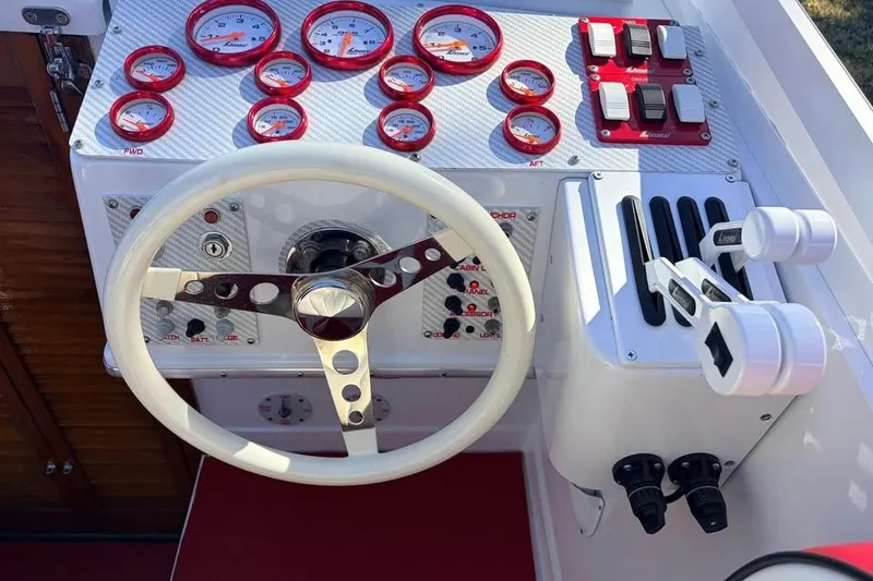 Slide: The Image of 1983 Cigarette 24' Classic boat dashboard with gauges, steering wheel, and control levers. - 5