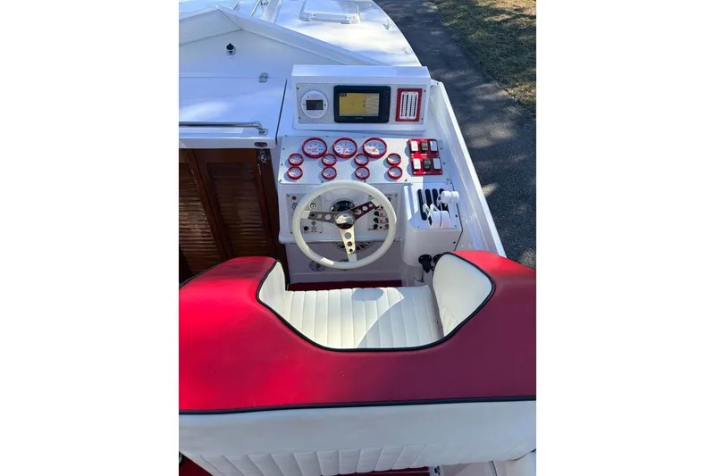 Slide: The Image of 1983 Cigarette 24' Classic boat cockpit with red and white seating, steering wheel, and gauges. - 6
