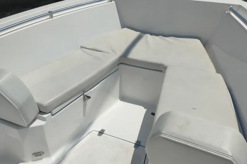 Slide: The Image of 2024 Aquasport 2200 Center Console boat seating area with white cushioned seats. - 4