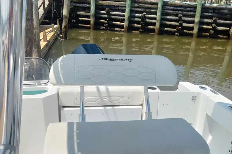 Slide: The Image of 2024 Aquasport 2200 Center Console boat interior near dock. - 6