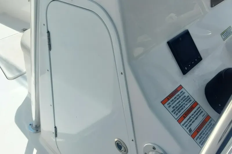 Slide: The Image of 2024 Aquasport 2200 Center Console interior with control panel and safety warnings. - 8