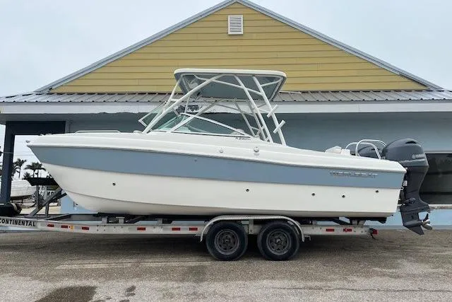 The Image of 2025 World Cat 230 SD boat on trailer, parked outside a building. - 1