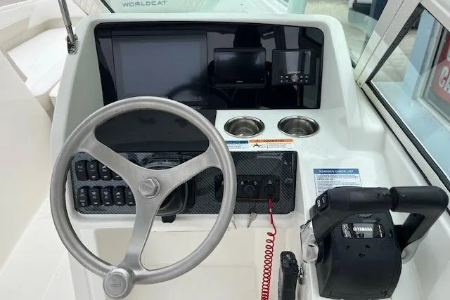 Slide: The Image of 2025 World Cat 230 SD boat dashboard with steering wheel, controls, and display screens. - 4