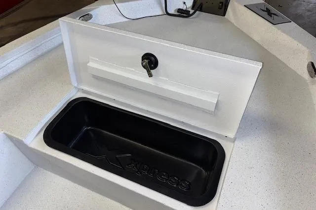 Slide: The Image of 2026 Xpress H20B Bay boat storage compartment with lockable lid and black interior. - 19