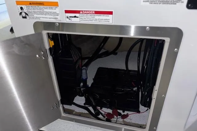 Slide: The Image of Open compartment of 2026 Xpress H20B Bay boat showing internal wiring and components. - 26