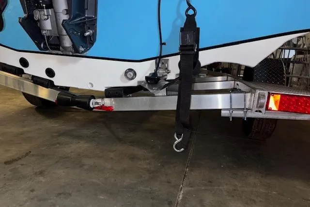 Slide: The Image of 2026 Xpress H20B Bay boat on trailer, showing rear view and securing strap. - 32