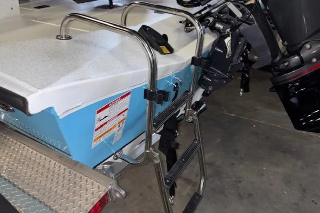 Slide: The Image of 2026 Xpress H20B Bay boat with ladder and motor in a garage setting. - 36