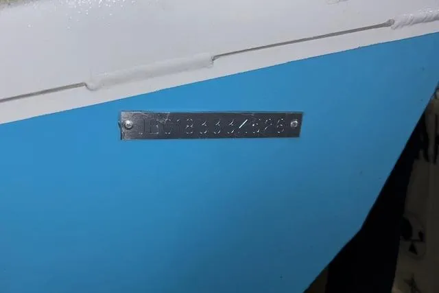 Slide: The Image of 2026 Xpress H20B Bay boat with identification plate on blue hull. - 37