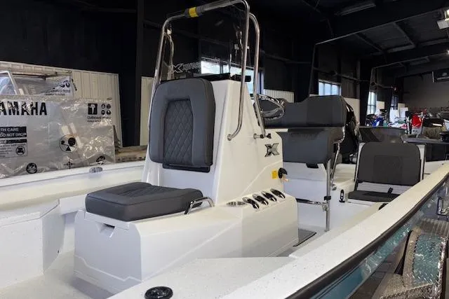 Slide: The Image of 2026 Xpress H20B Bay boat interior with seating and console in showroom. - 4