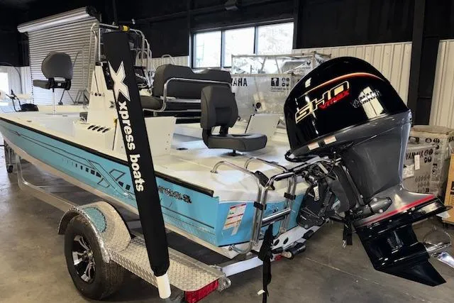 Slide: The Image of 2026 Xpress H20B Bay boat with powerful outboard motor in a showroom. - 6