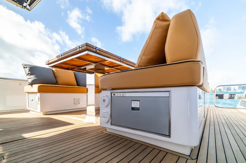 Slide: The Image of Luxurious 2023 Pardo Yachts 50 deck with cushioned seating and wooden table. - 11