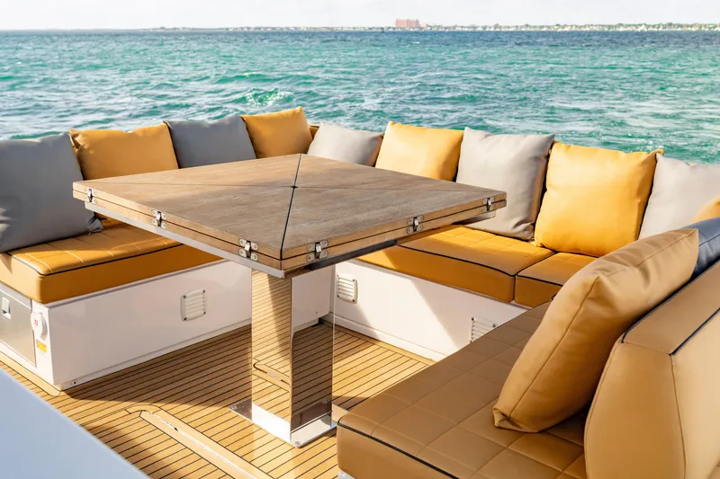 Slide: The Image of Luxury seating area on 2023 Pardo Yachts 50, featuring elegant cushions and wooden table. - 19